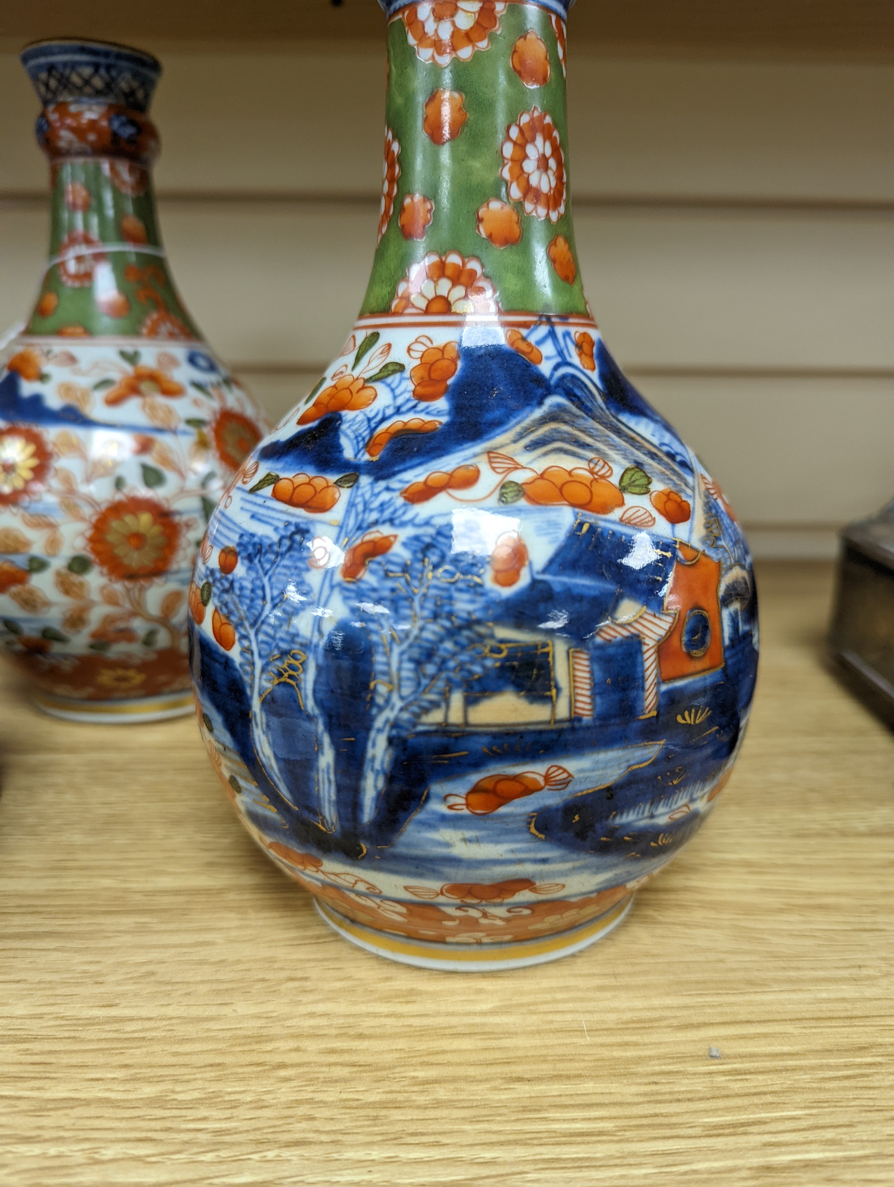 A pair of 18th century Chinese clobbered blue and white bottle vases 23cm